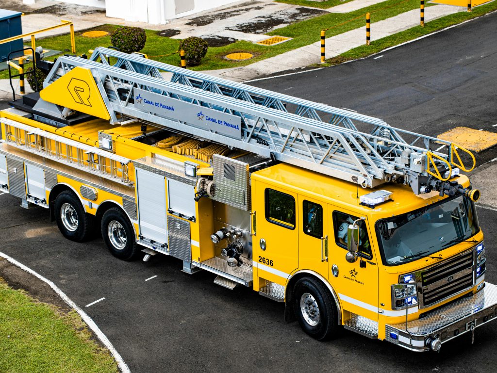 A vibrant yellow fire truck at the Canal De Panama, showcasing emergency preparedness.